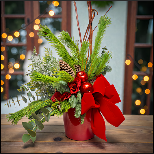 Christmas flower arrangement with red bow and decorations. 