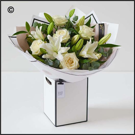A soothing bouquet of white roses and lilies. Elegant and graceful