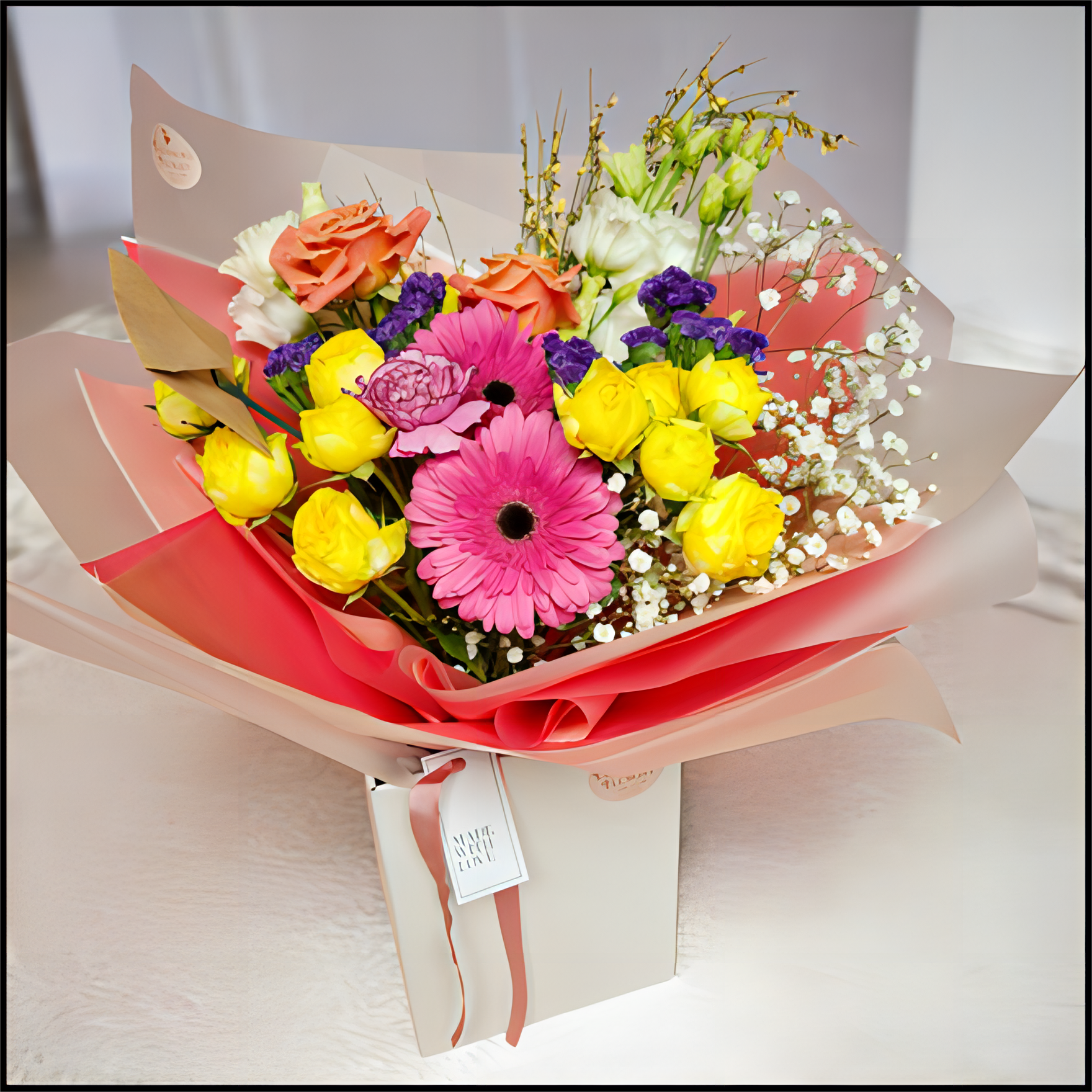 Bouquet of colourful flowers wrapped in pink paper