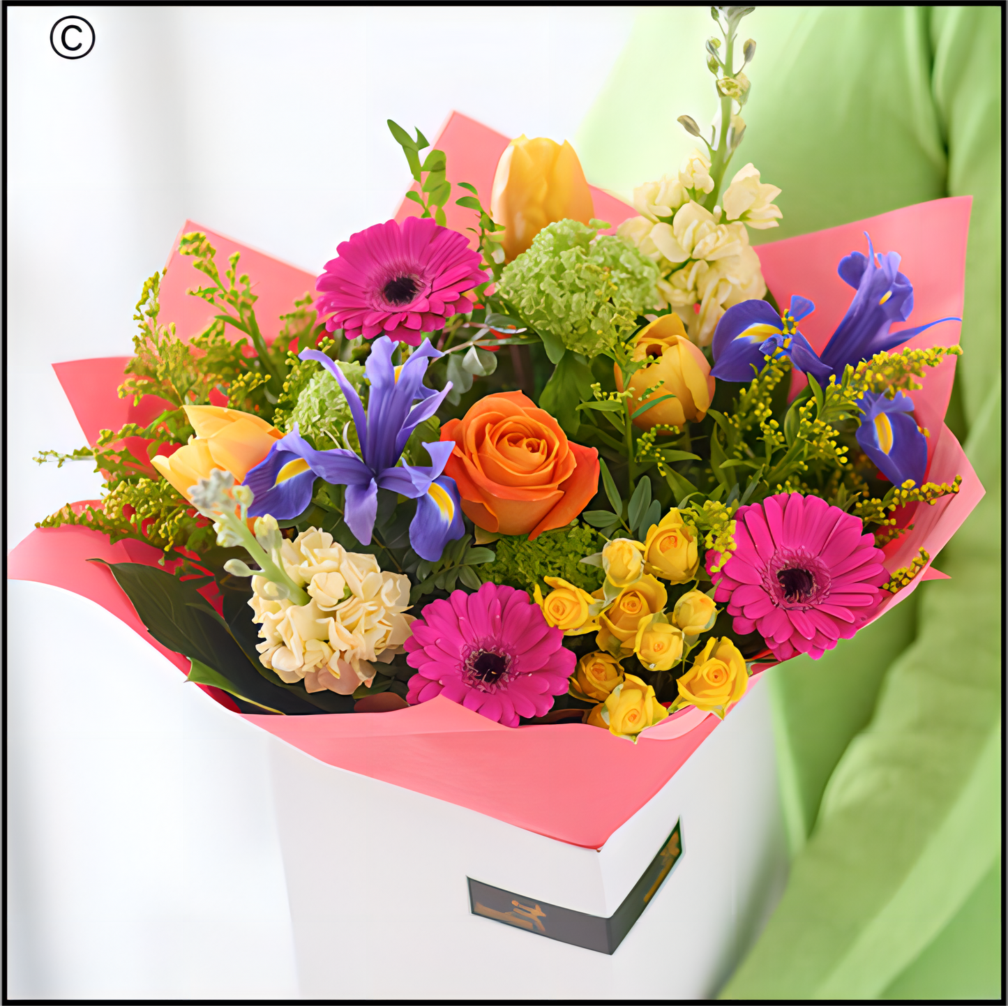 Colourful bouquet of flowers wrapped in pink paper 
