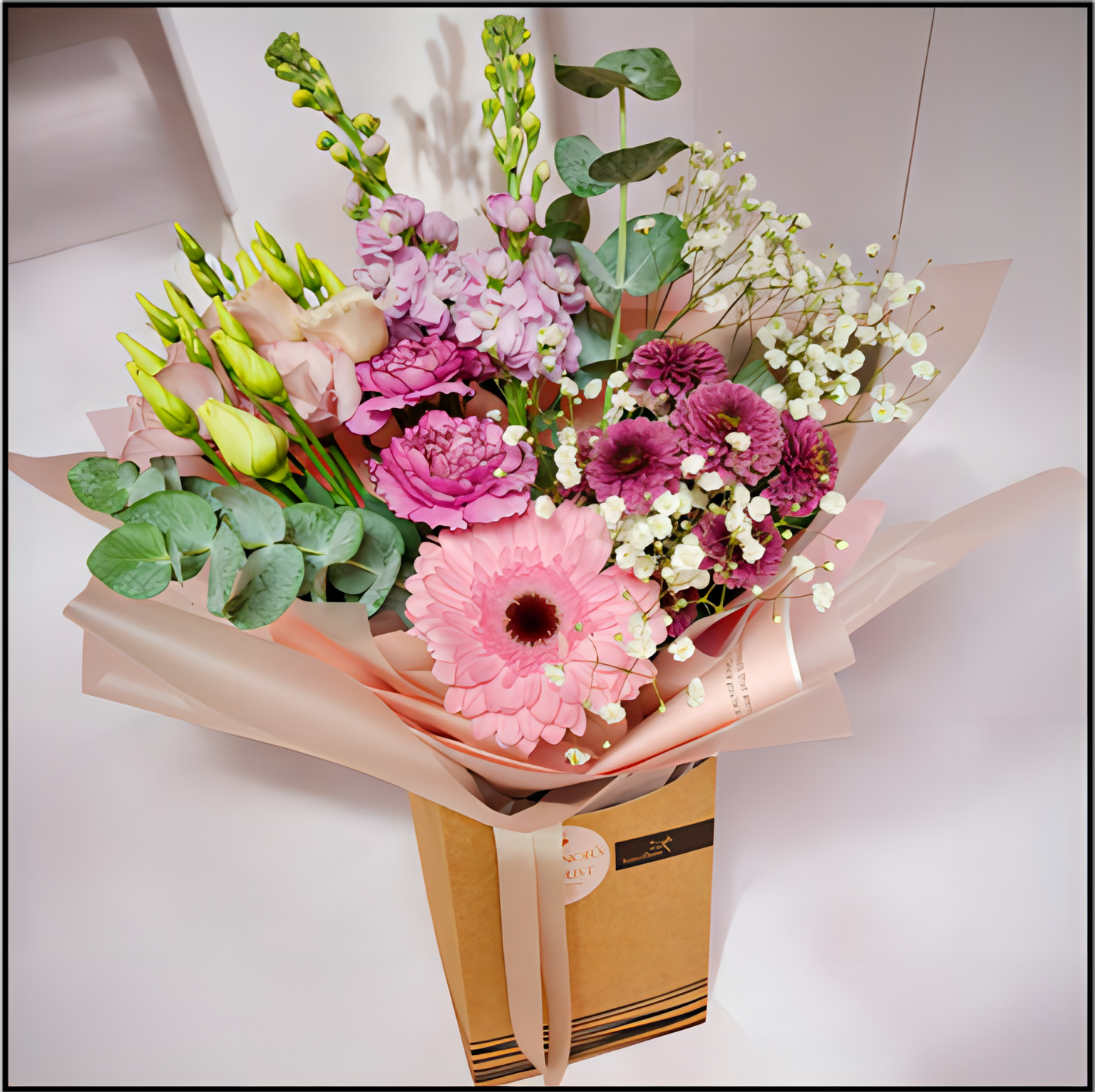 Bouquet of flowers wrapped in brown paper contained in a box